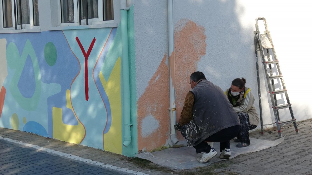 Okul duvarlarını gönül gözüyle renklendiriyor
