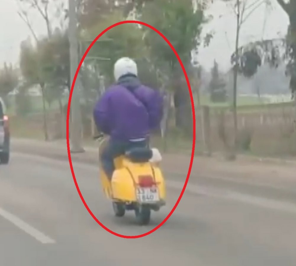 Elleri montunun cebinde olan motosiklet sürücüsü, kamerada