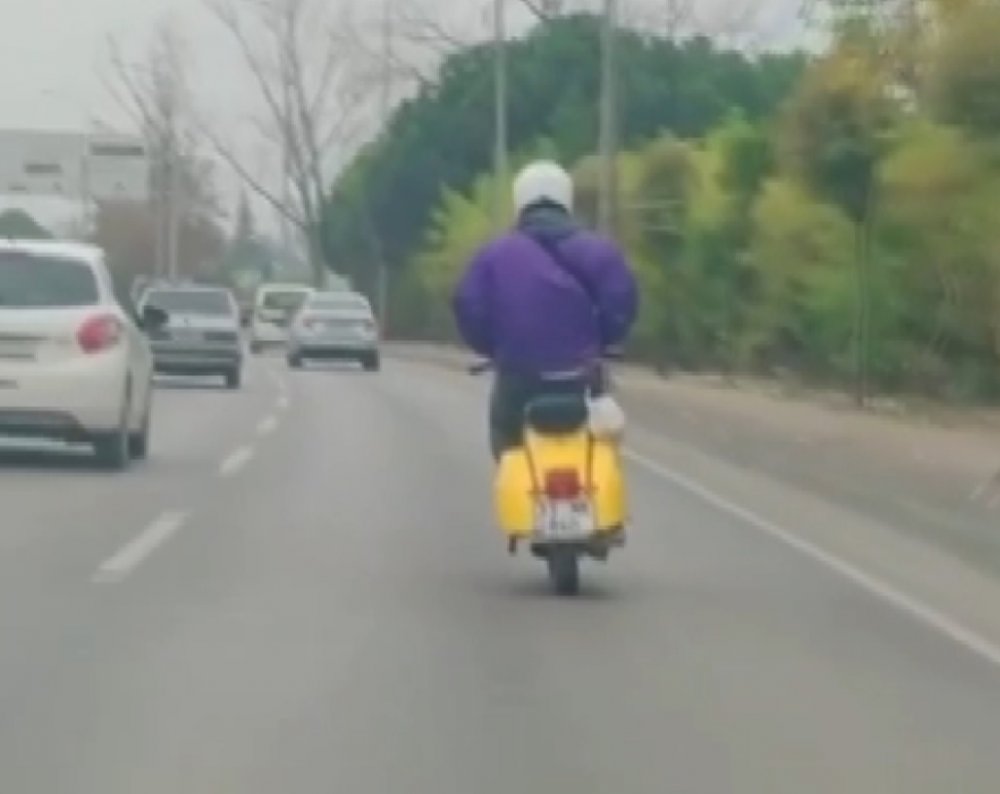 Elleri montunun cebinde olan motosiklet sürücüsü, kamerada