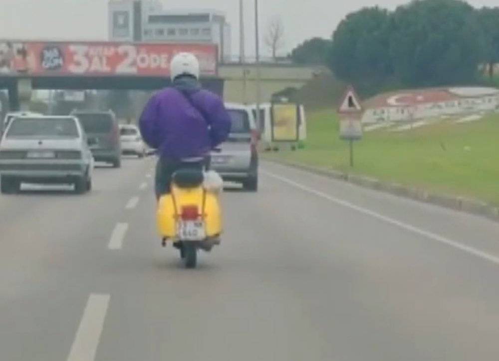 Elleri montunun cebinde olan motosiklet sürücüsü, kamerada