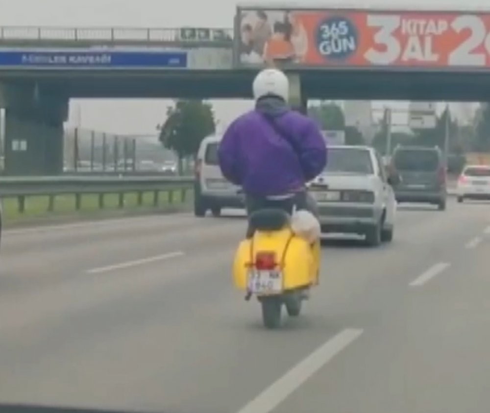 Elleri montunun cebinde olan motosiklet sürücüsü, kamerada