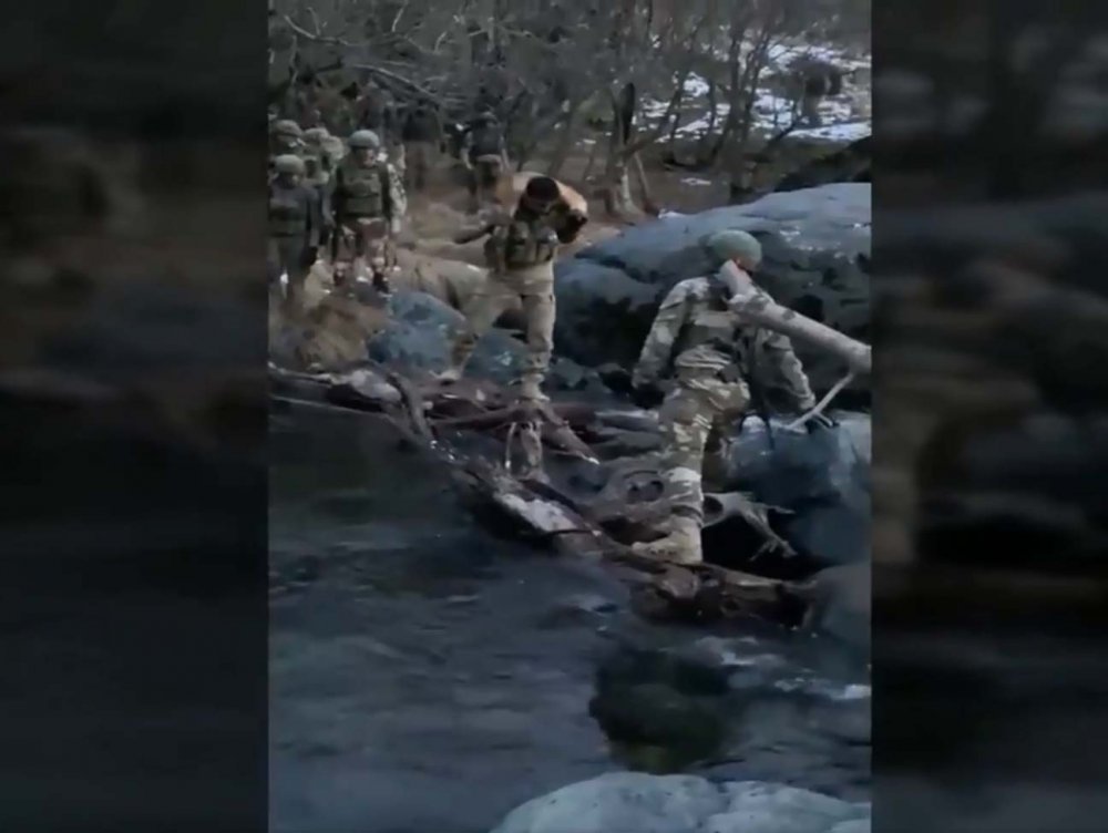 Mehmetçik, nehirden karşıya geçerken köpeğini omzunda taşıdı
