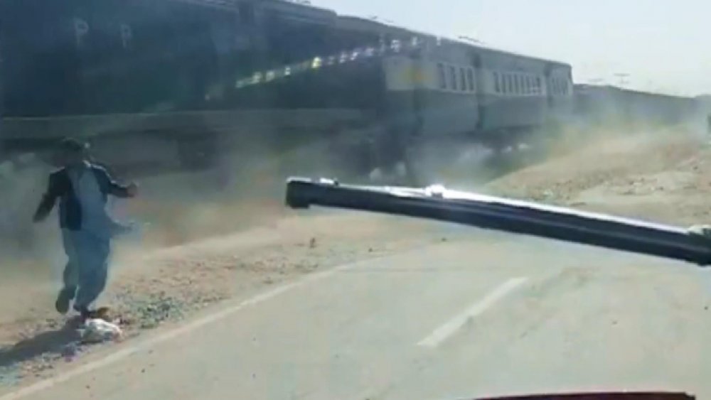 Pakistan’da motosiklet sürücüsünün trenden son anda kurtulma anı kamerada