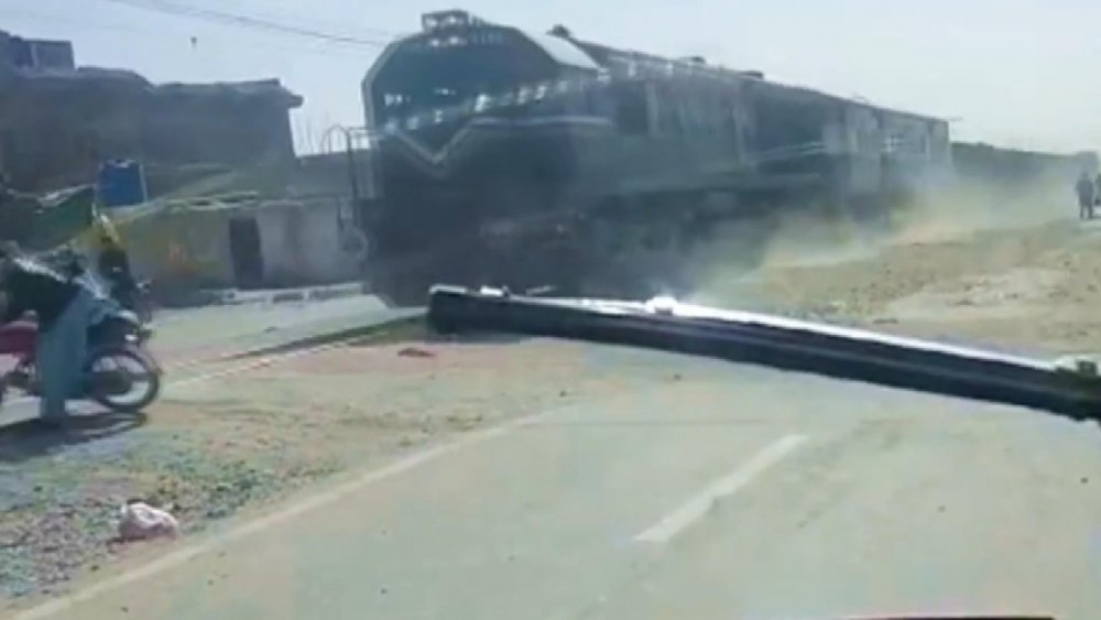 Pakistan’da motosiklet sürücüsünün trenden son anda kurtulma anı kamerada