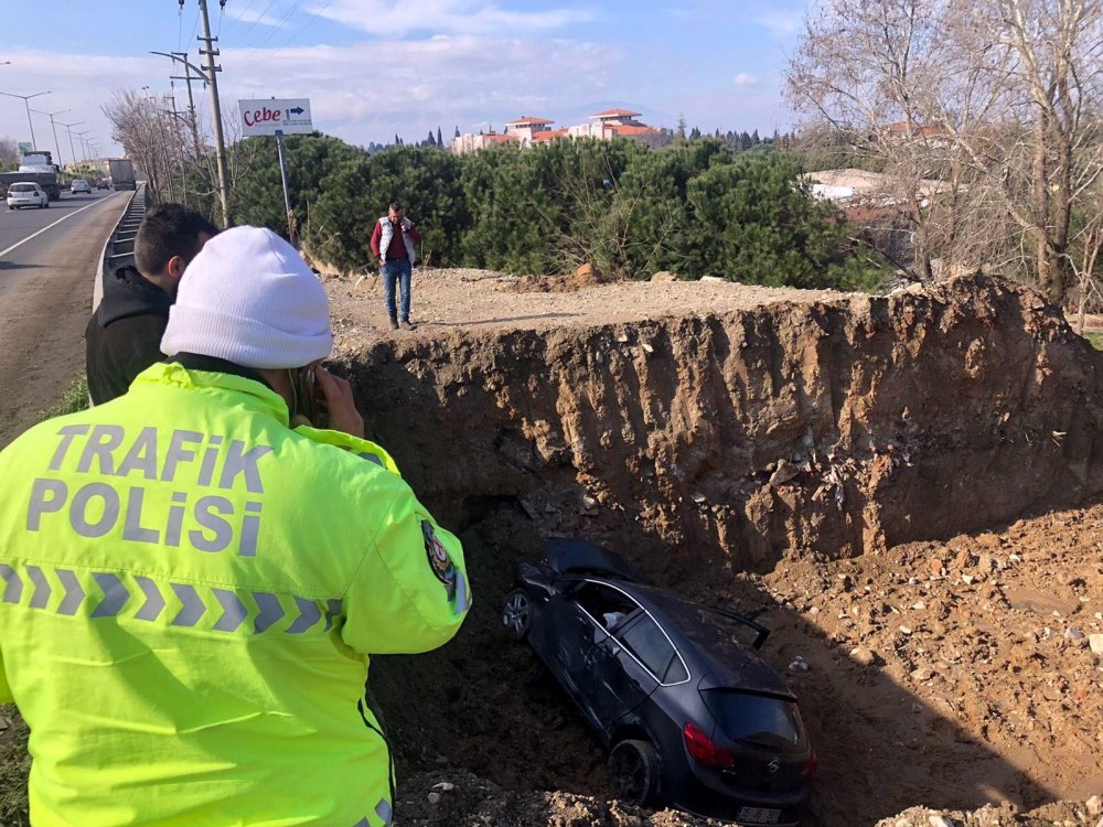 Otomobil, sağından geçtiği TIR'a çarpıp temel çukuruna uçtu