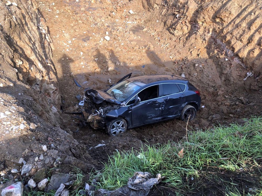 Otomobil, sağından geçtiği TIR'a çarpıp temel çukuruna uçtu
