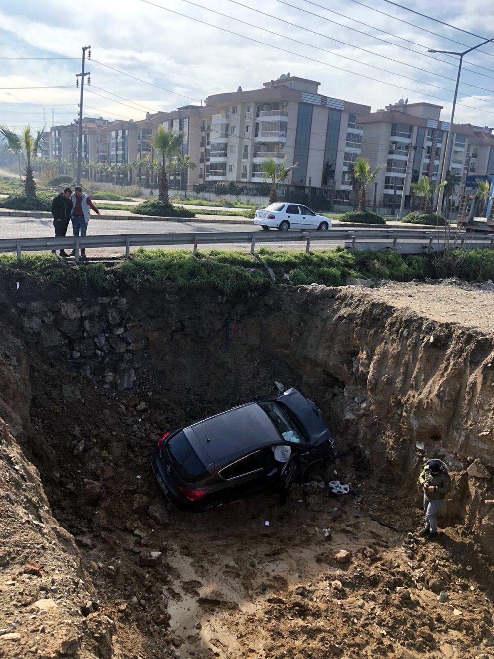Otomobil, sağından geçtiği TIR'a çarpıp temel çukuruna uçtu