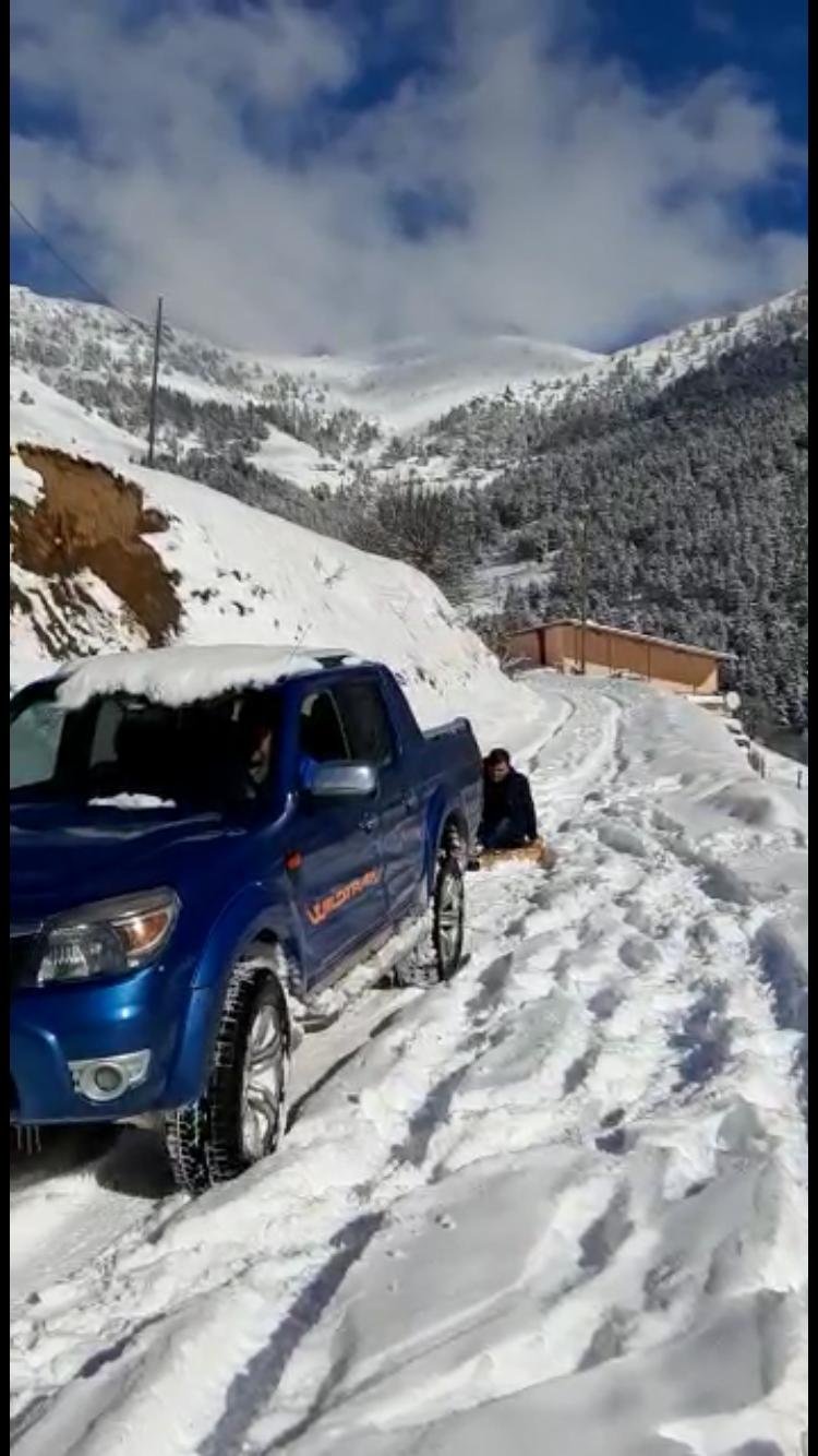 Kamyonete bağlı tahtalı düzeneğe oturan grup, kar küreyip kaydı