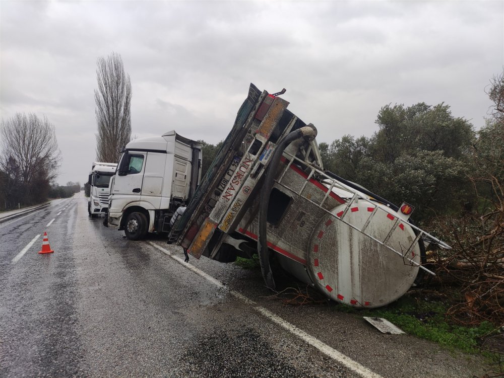 Kayganlaşan yolda devrilenTIR'ın taşıdığı tanker zeytinliğe savruldu